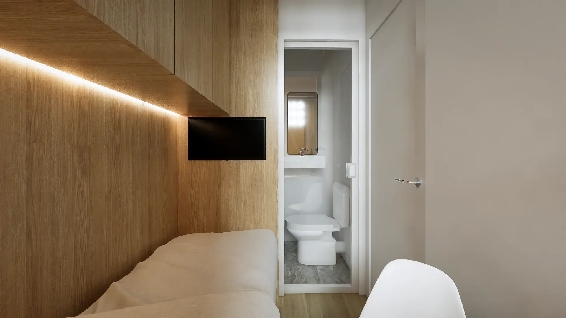 View from the bed toward the wall-mounted television and compact ensuite bathroom